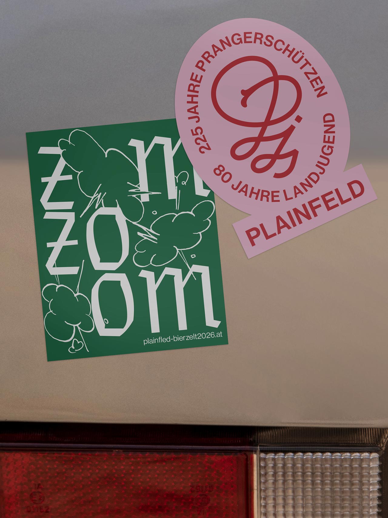 Green typographic sticker and pink association sticker on a metal surface