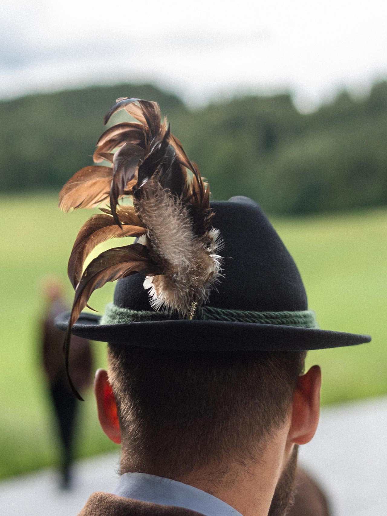 Rear view of a person wearing a traditional feathered hat