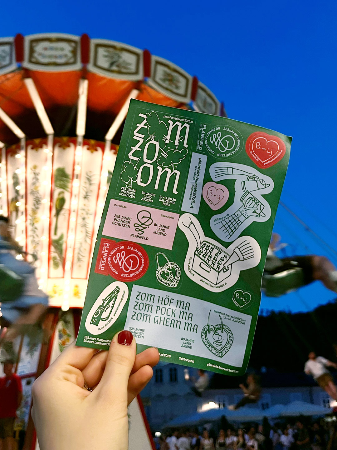 Green sheet of event stickers in front of a fairground ride