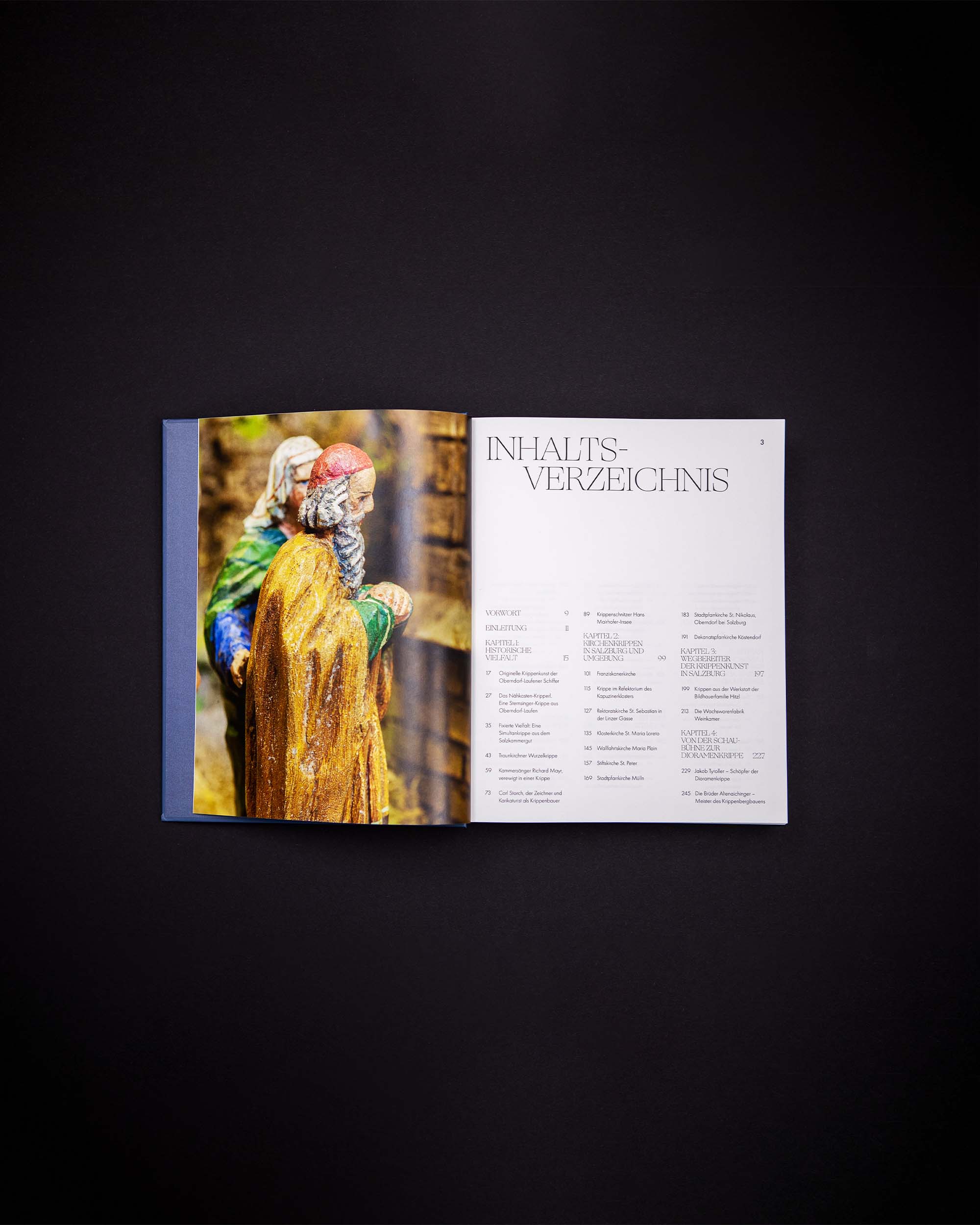 Open nativity-scene book with a full-page figure photograph and contents