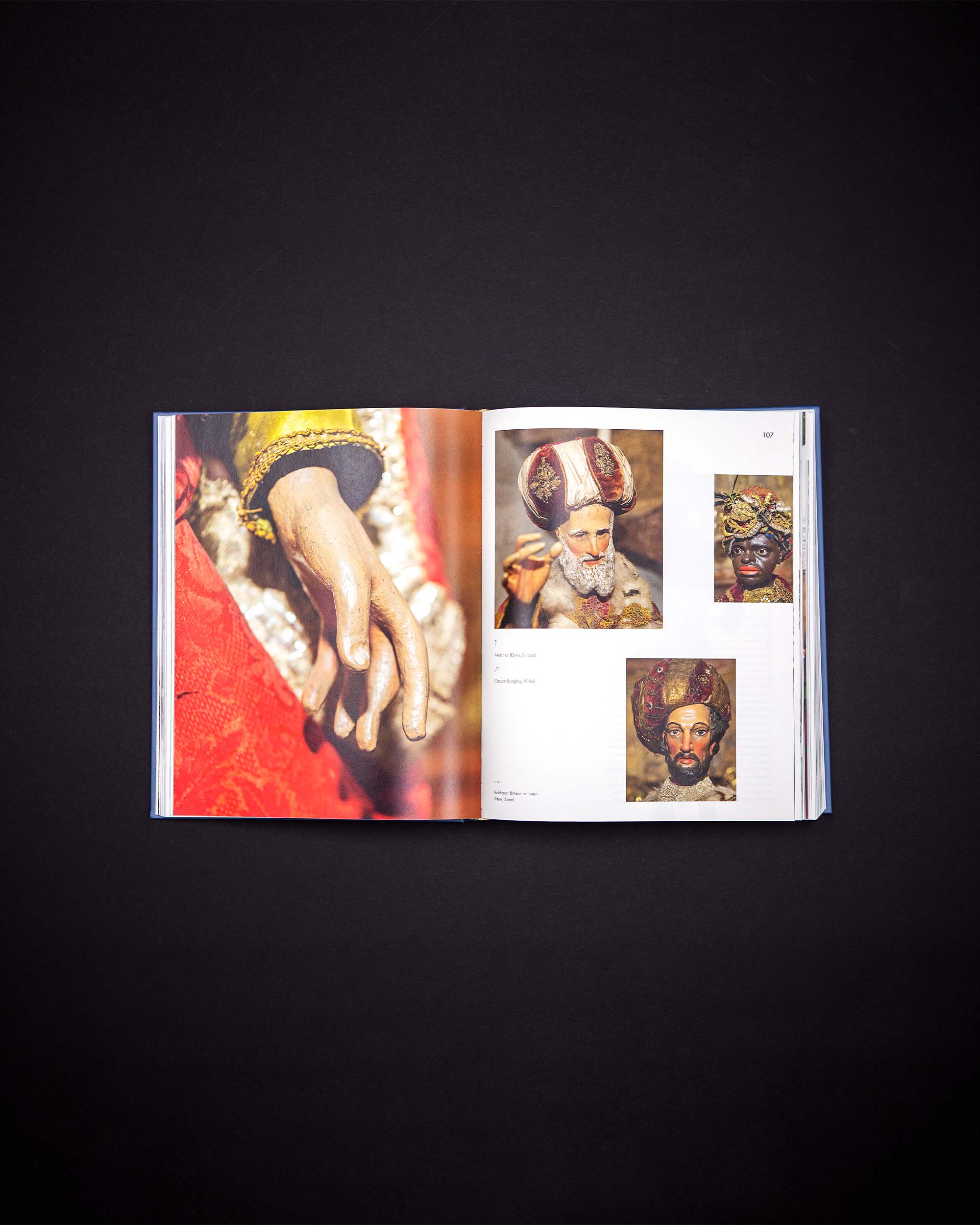 Book spread with several detailed photographs of painted nativity figures