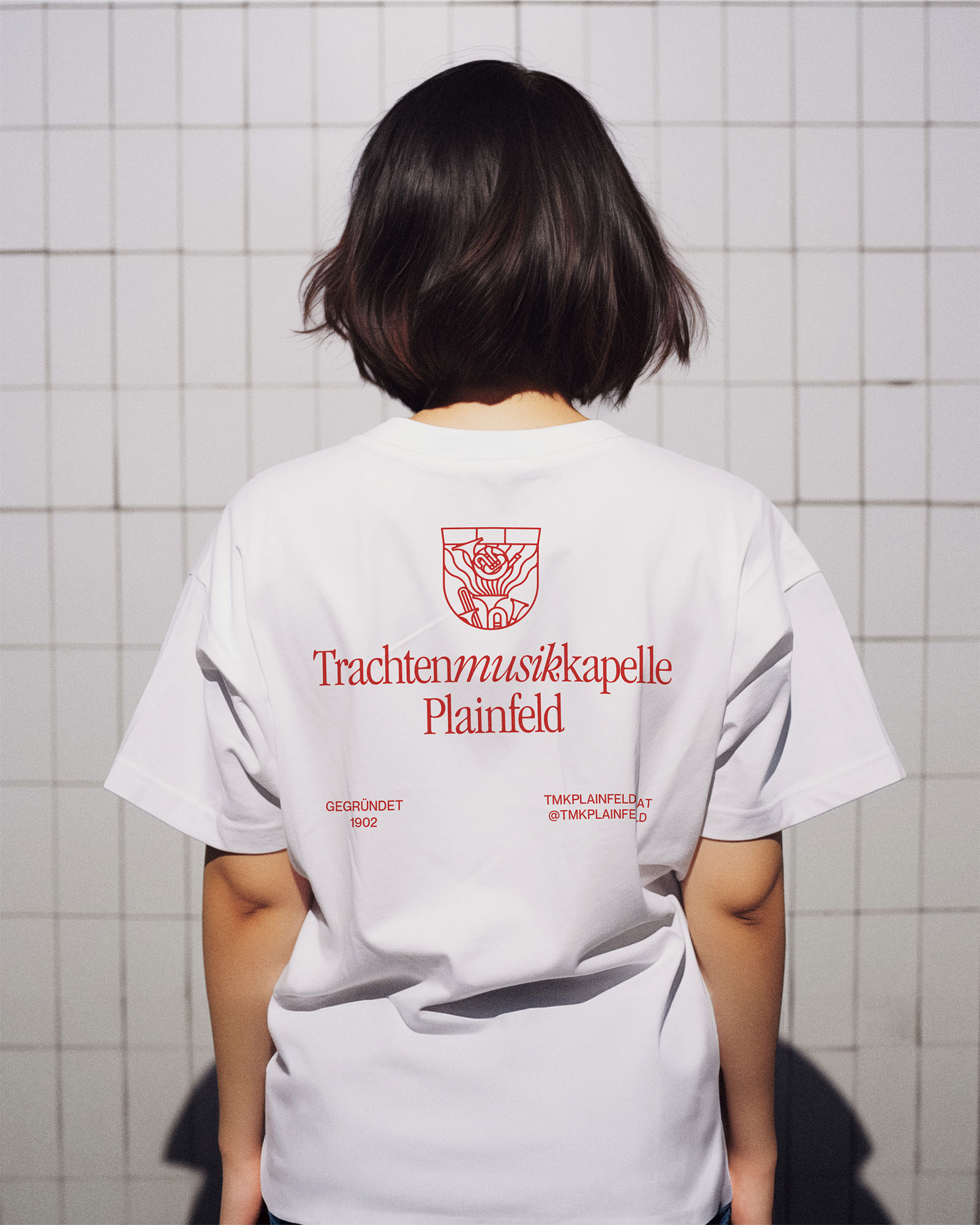 Person wearing a white T-shirt with the red band logo on the back