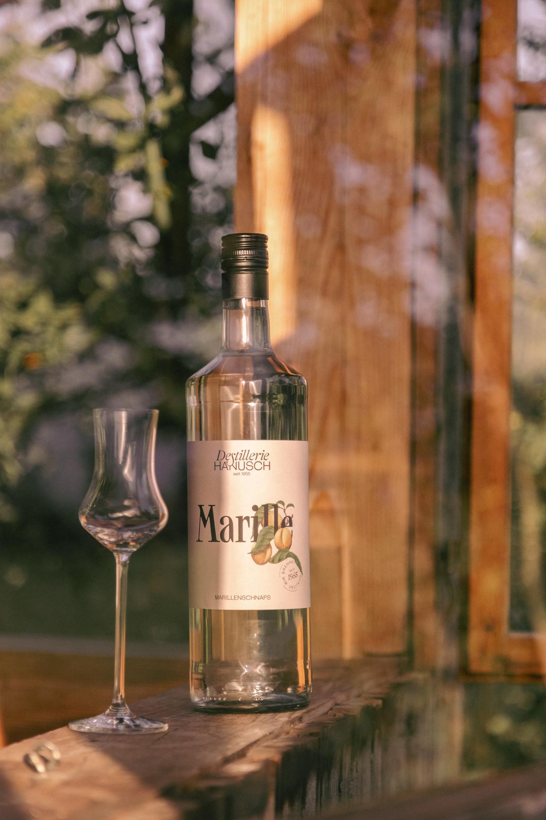 Apricot spirit bottle and glass in warm sunlight