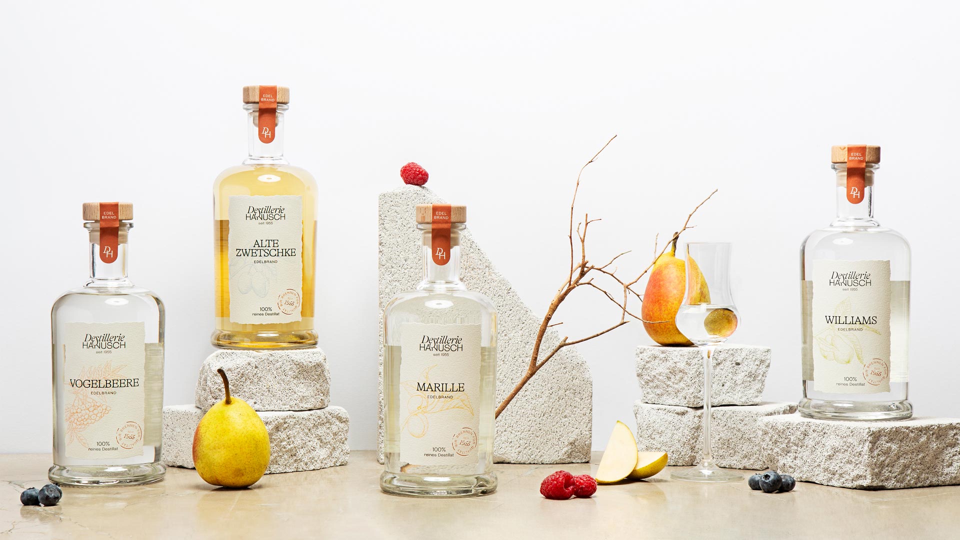 Hanusch spirits with fruit and branches on pale plinths