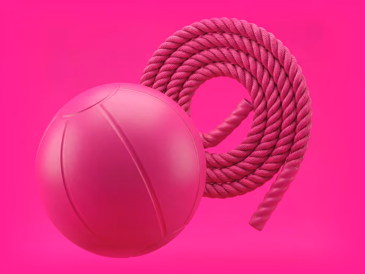 Pink basketball next to a coiled pink rope on a solid pink background.