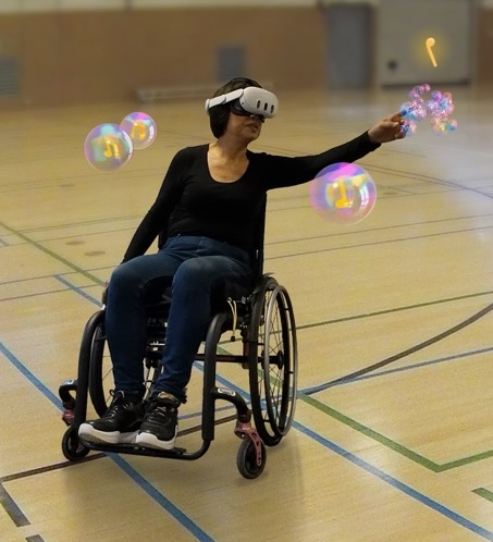 Person in wheelchair wearing VR headset reaching out in gym with floating colorful musical notes.
