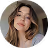 Portrait d'une femme souriante aux cheveux blonds portant un chapeau beige.