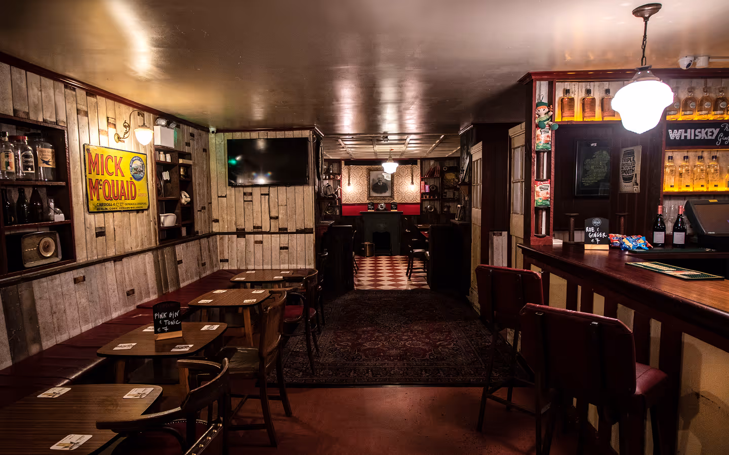 Traditional pub interior with hardware-shop drawers, vintage enamel signs and whiskey shelves at Mary's Bar & Hardware