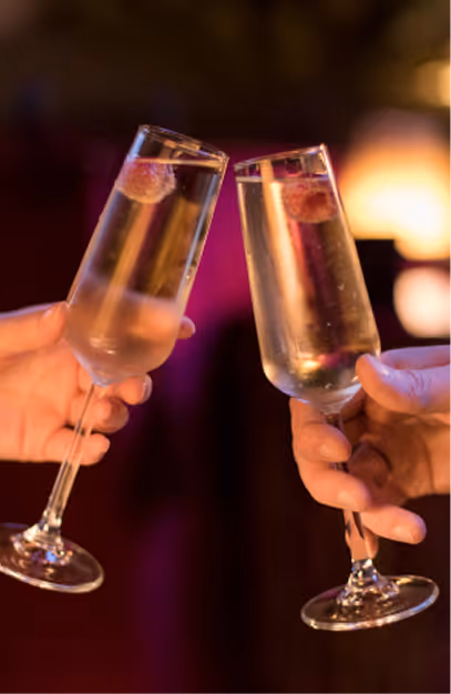 Two sparkling wine flutes with berries toasted at Stella Cocktail Club