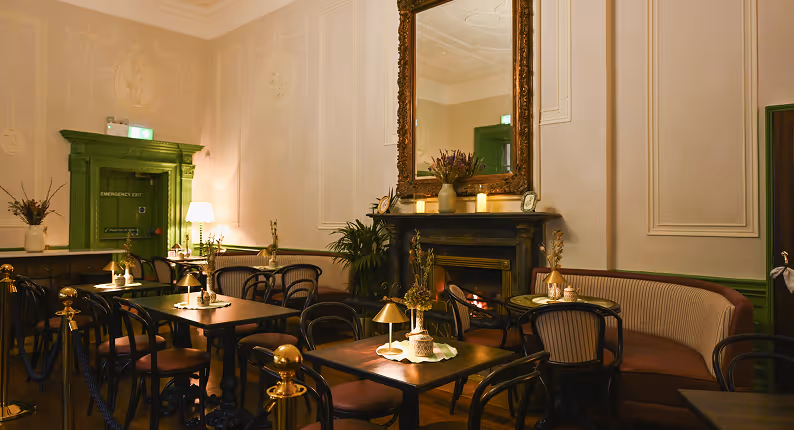 Amelia's Table dining room with elegant seating, tables, warm lighting and a decorative fireplace.