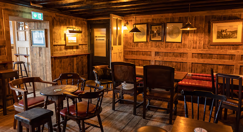 Timber-panelled snug with leather chairs and hunting prints at the Foxhunter