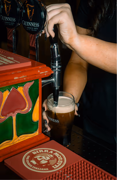Bartender pulling a pint of Guinness at the taps in Foxhunter