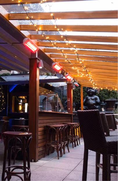 Heated timber pergola terrace strung with fairy lights and bar stools at Fade St. Social