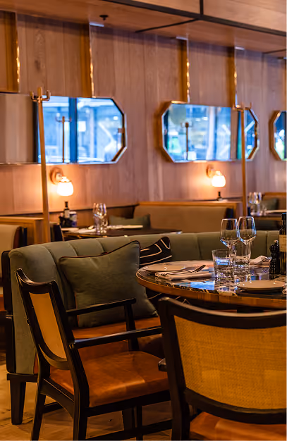 Isabelle's restaurant dining room with elegant tables, upholstered seating, warm lighting and wood-panelled walls.