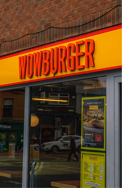 Yellow and red Wowburger shopfront sign above the restaurant's glass frontage