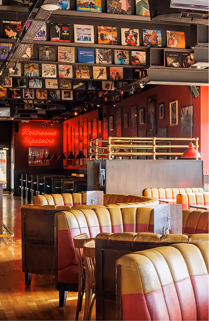 Vinyl record covers overhead and red and cream booths at Captain Americas
