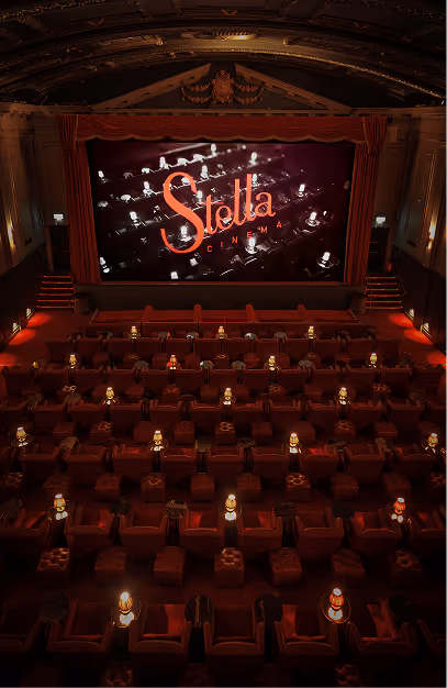 Armchair seating and lamps facing the curtained screen in the auditorium at Stella Cinema