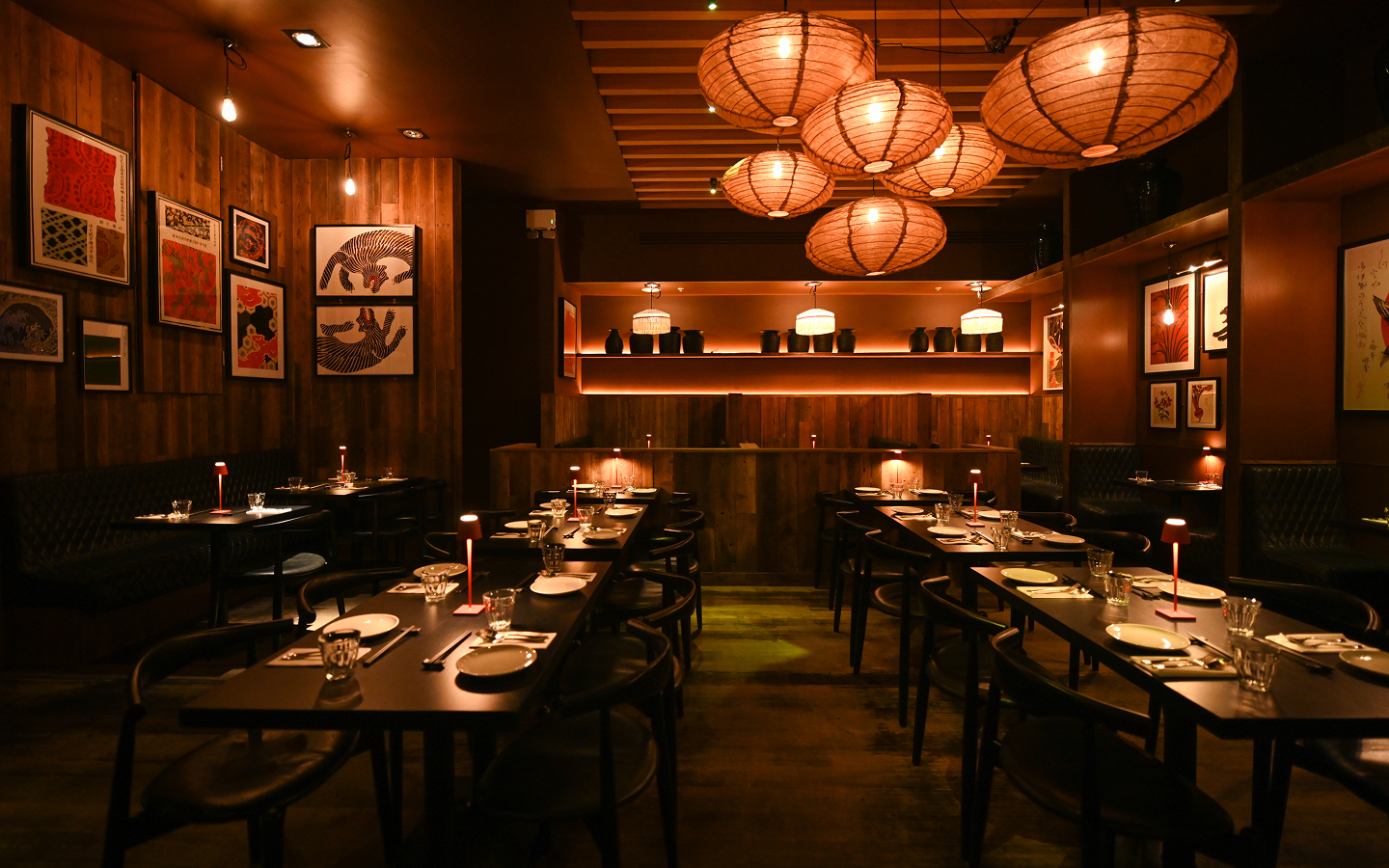 Set tables under paper lanterns in the timber-lined dining room at Kaldero
