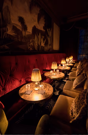 Stella Cocktail Club's intimate lounge with red velvet seating and candlelit tables