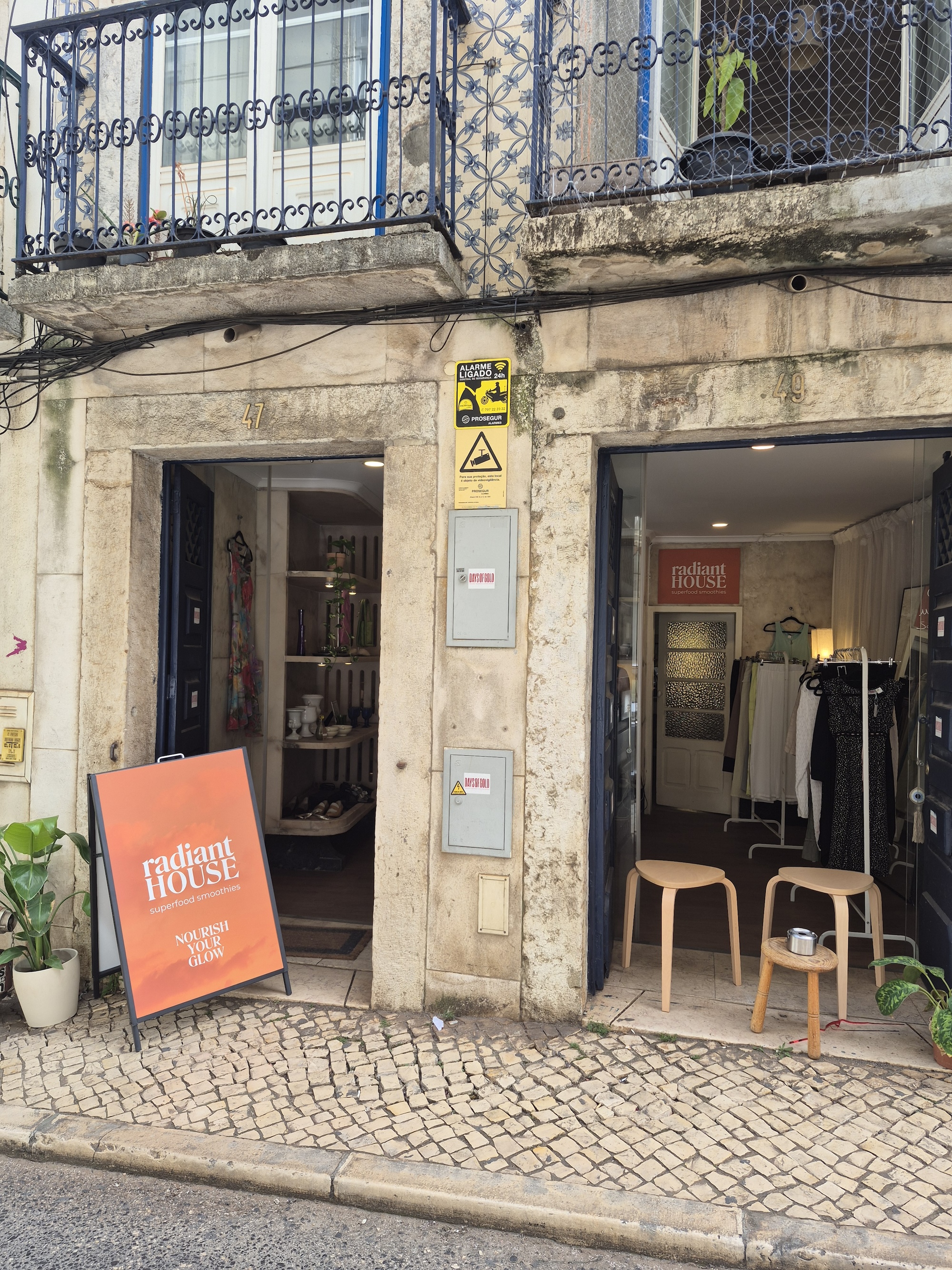 the RadiantHouse orange A-frame smoothie sign in front of the Days of Gold Vintage Shop in Lisbon Portugal