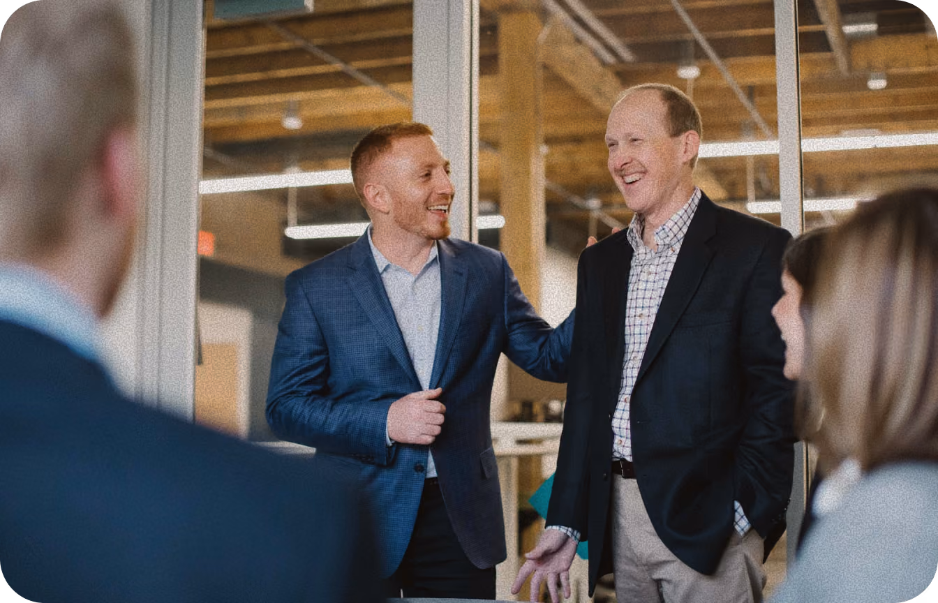 two men talking to each other in an office setting
