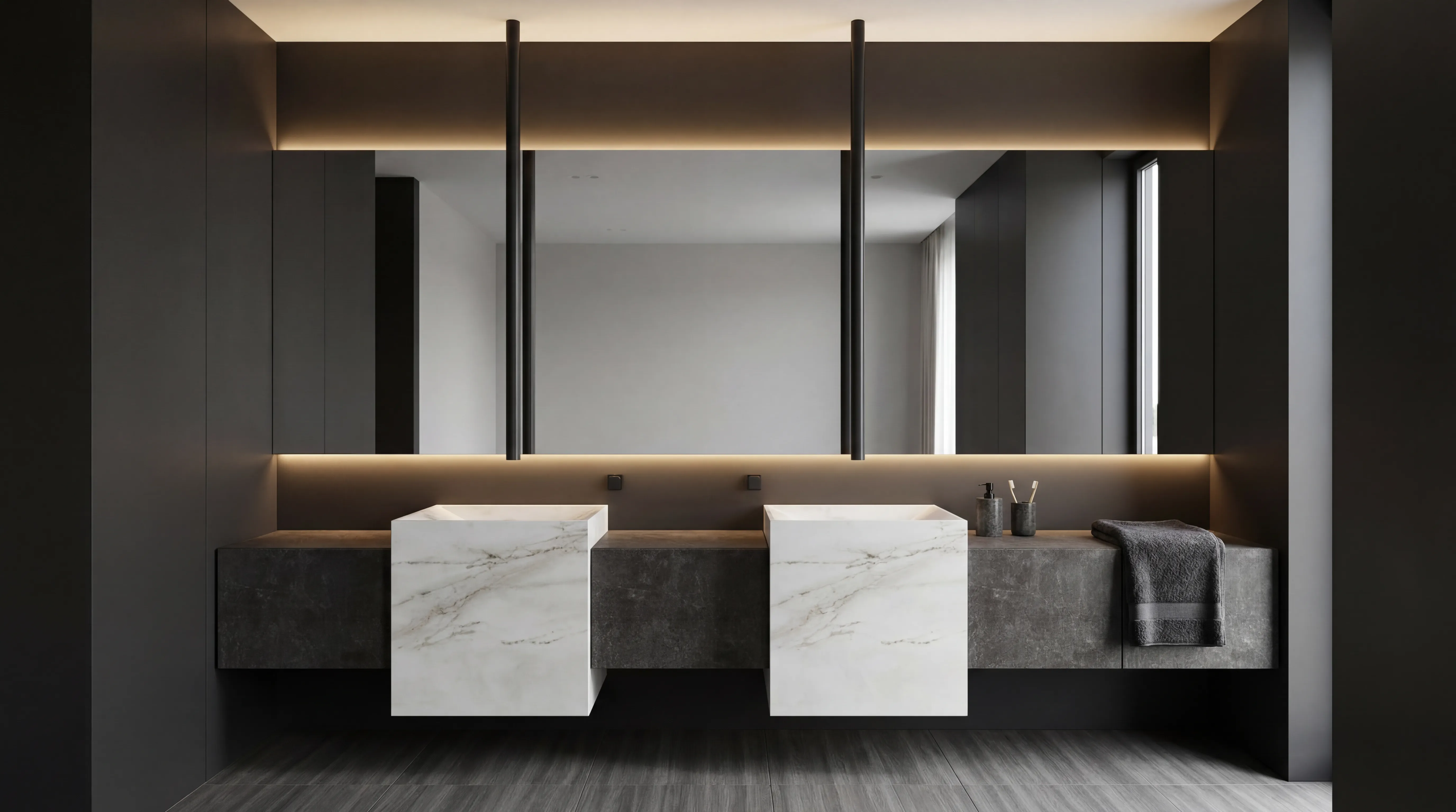 A floating vanity in a dark, low-lit bathroom — two carved marble basins on a stone counter, backlit mirror set flush into the wall.
