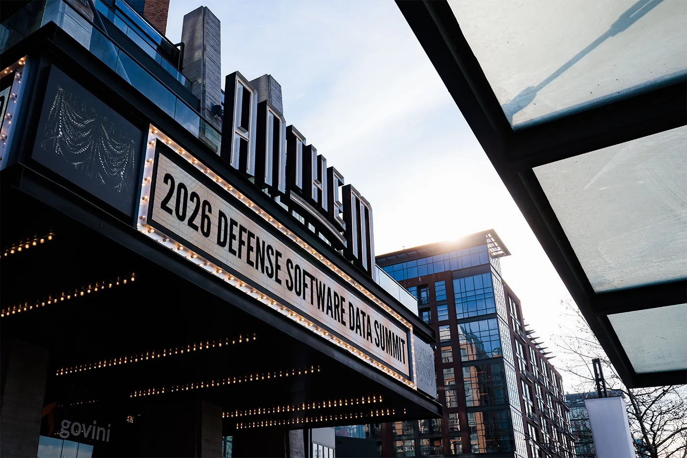Marquee sign at Anthem building displaying 2026 Defense Software & Data Summit with city buildings in background.