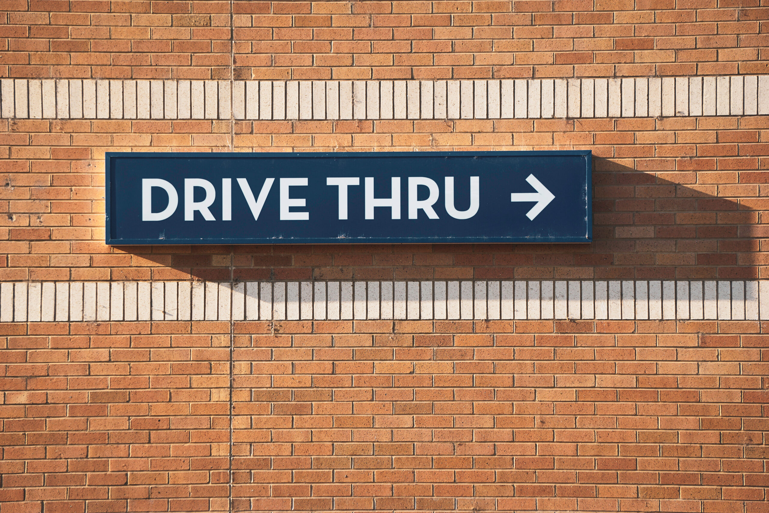 Drive thru sign on brick wall