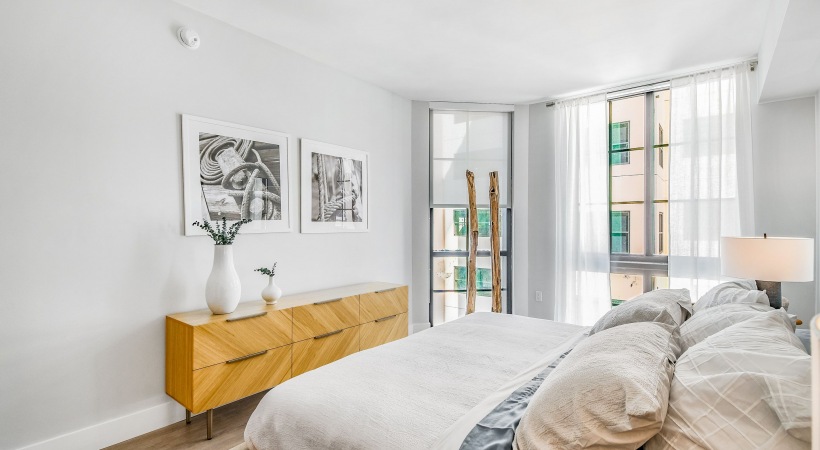 Bedroom with bed and large floor to ceiling windows 