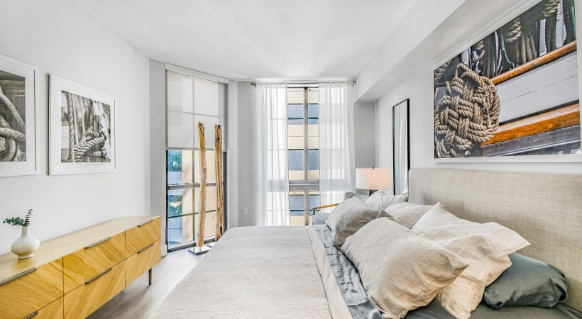 Bedroom with bed and large floor to ceiling windows 