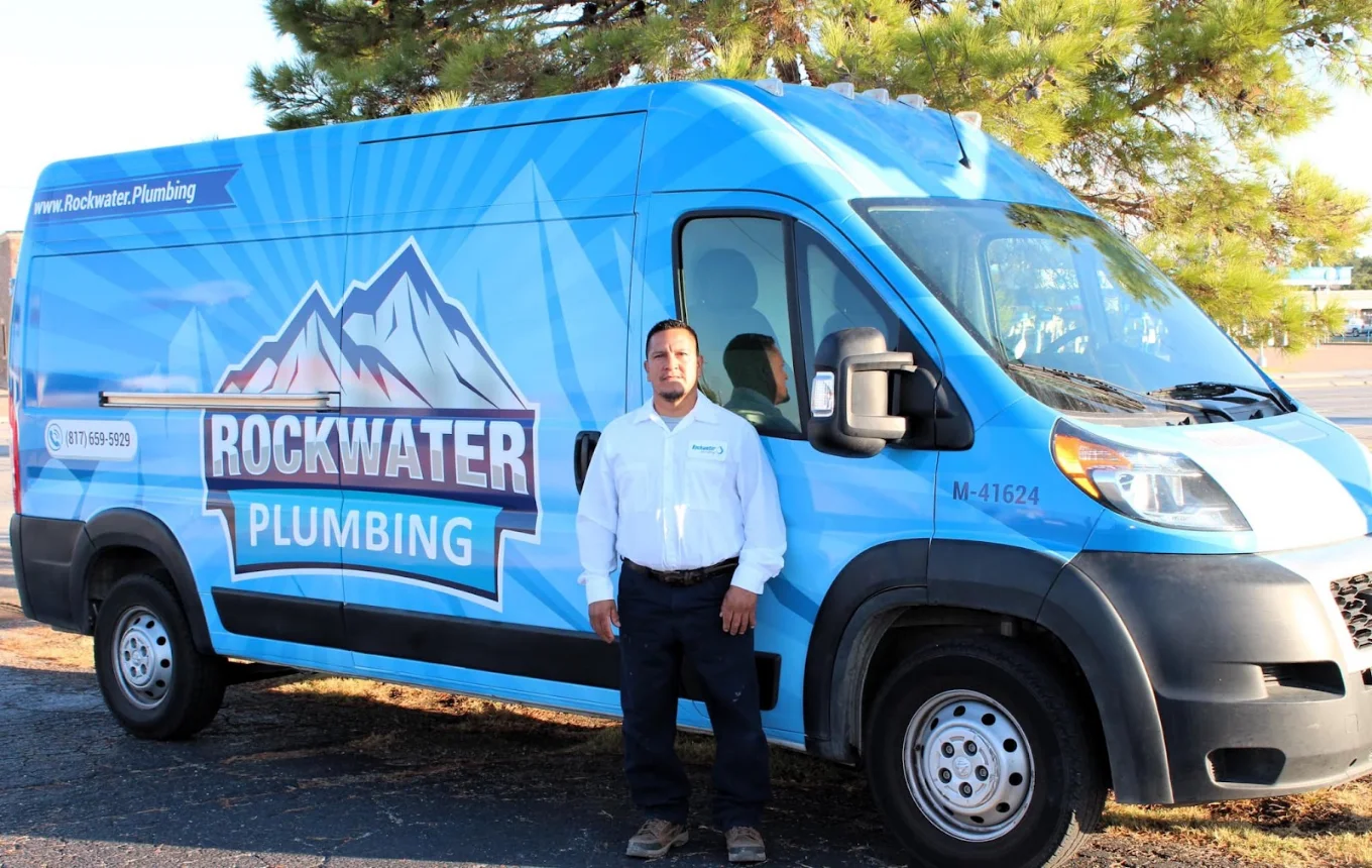 plumber in front of a plumbing services van
