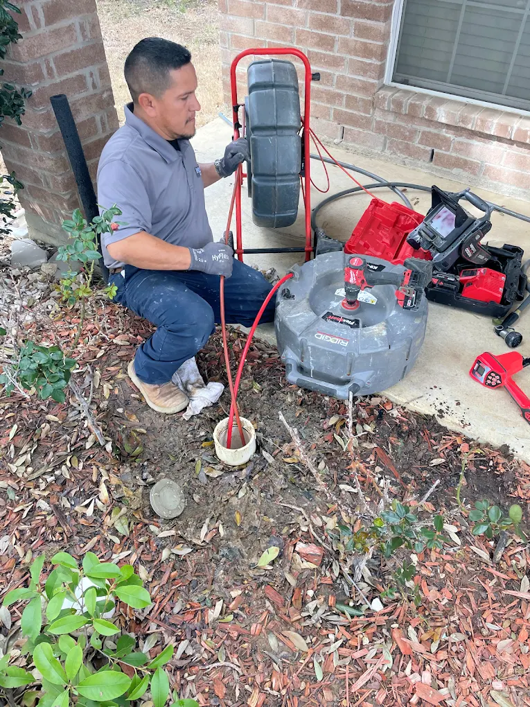 plumber servicing a drain outside