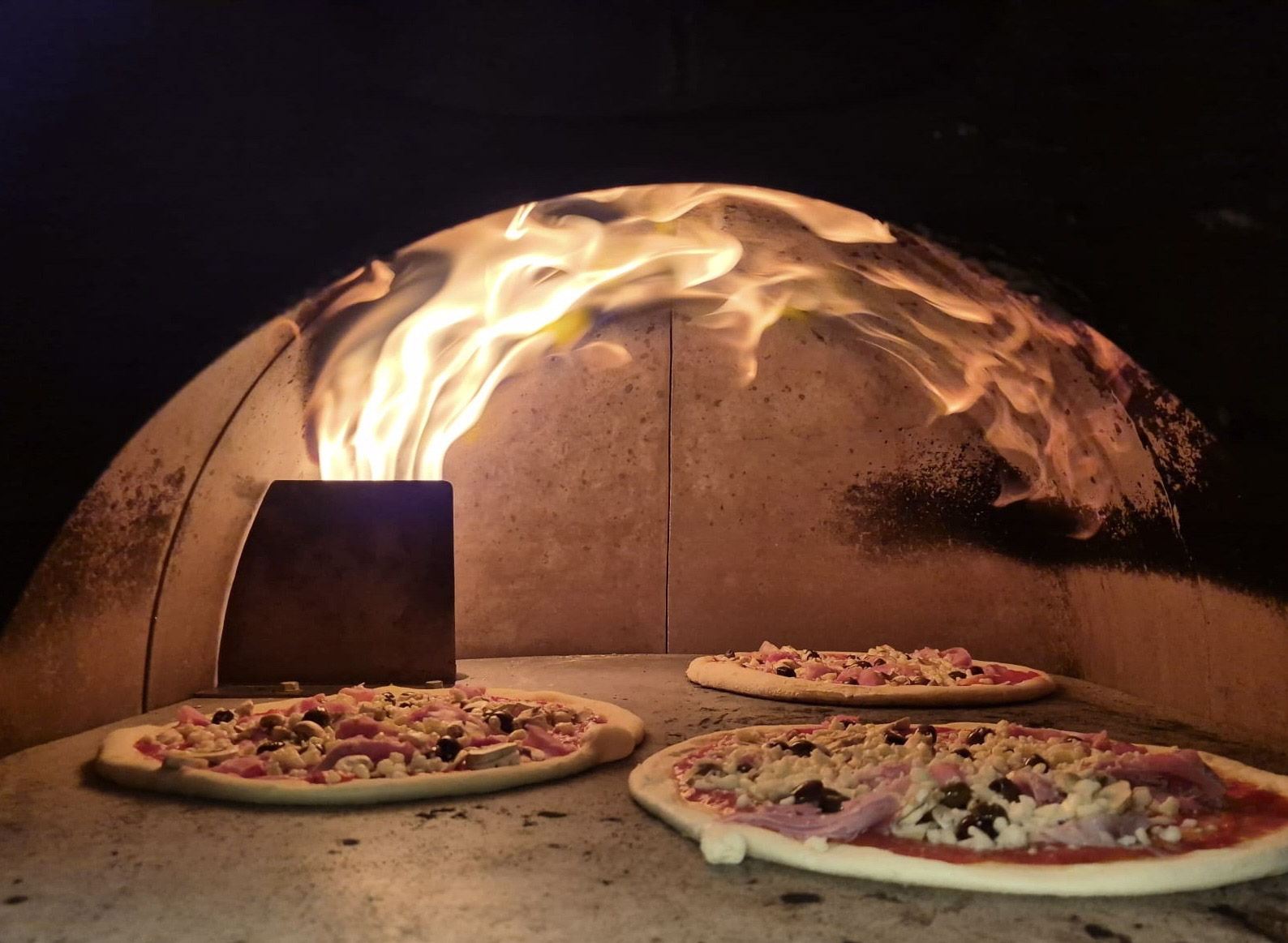 Pizze in cottura nel forno a legna