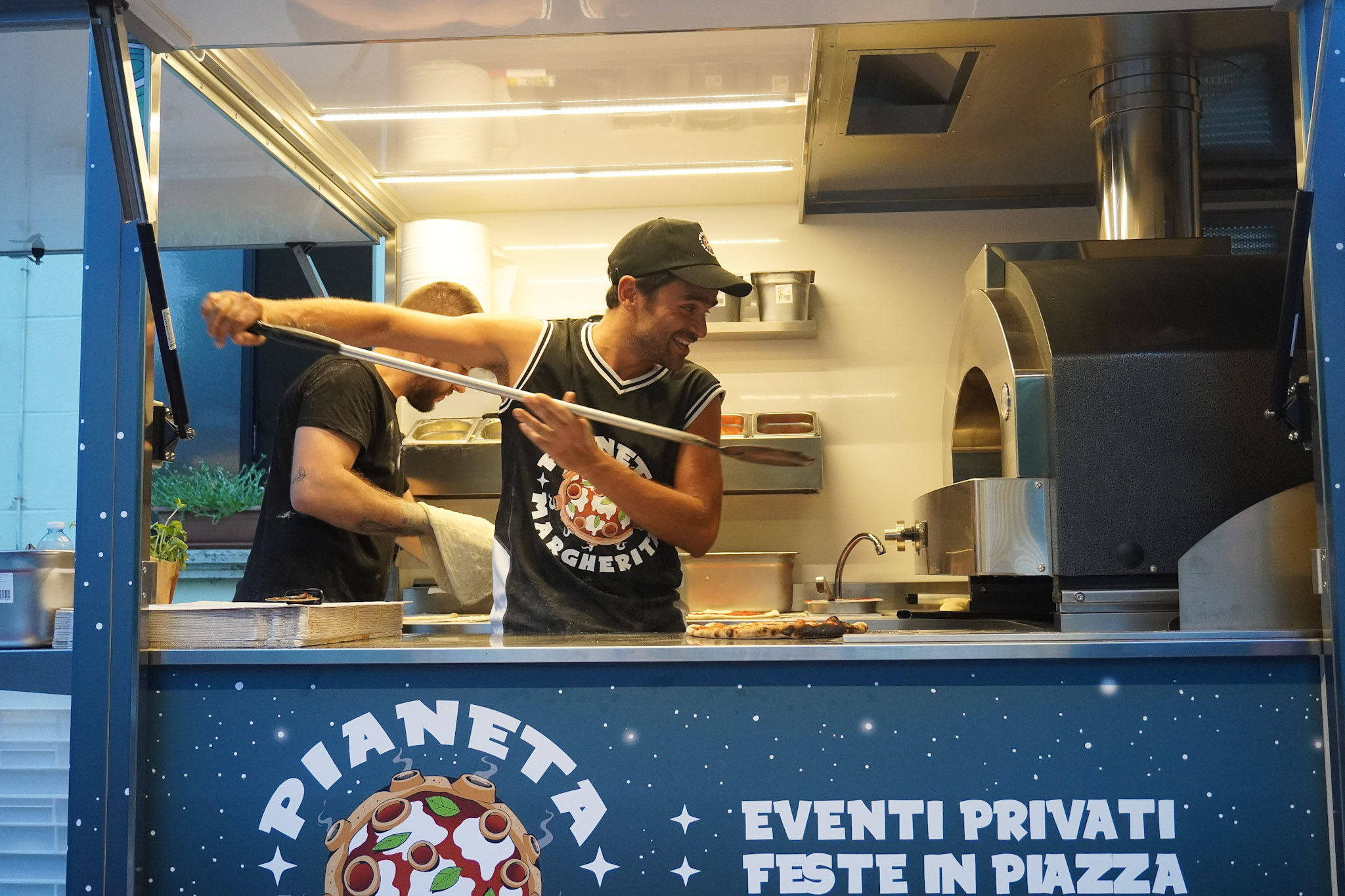 Pizzaiolo intento ad infornare una pizza