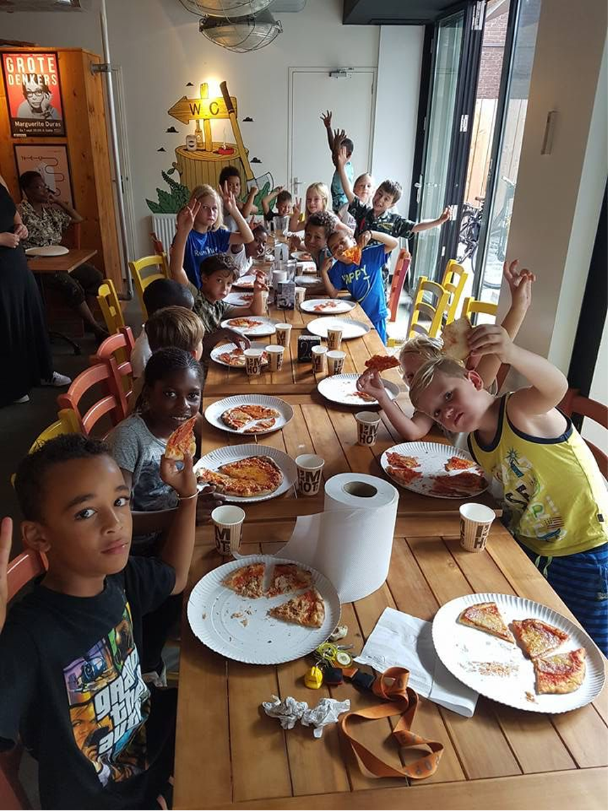 Tavolata di bambini che mangiano pizza