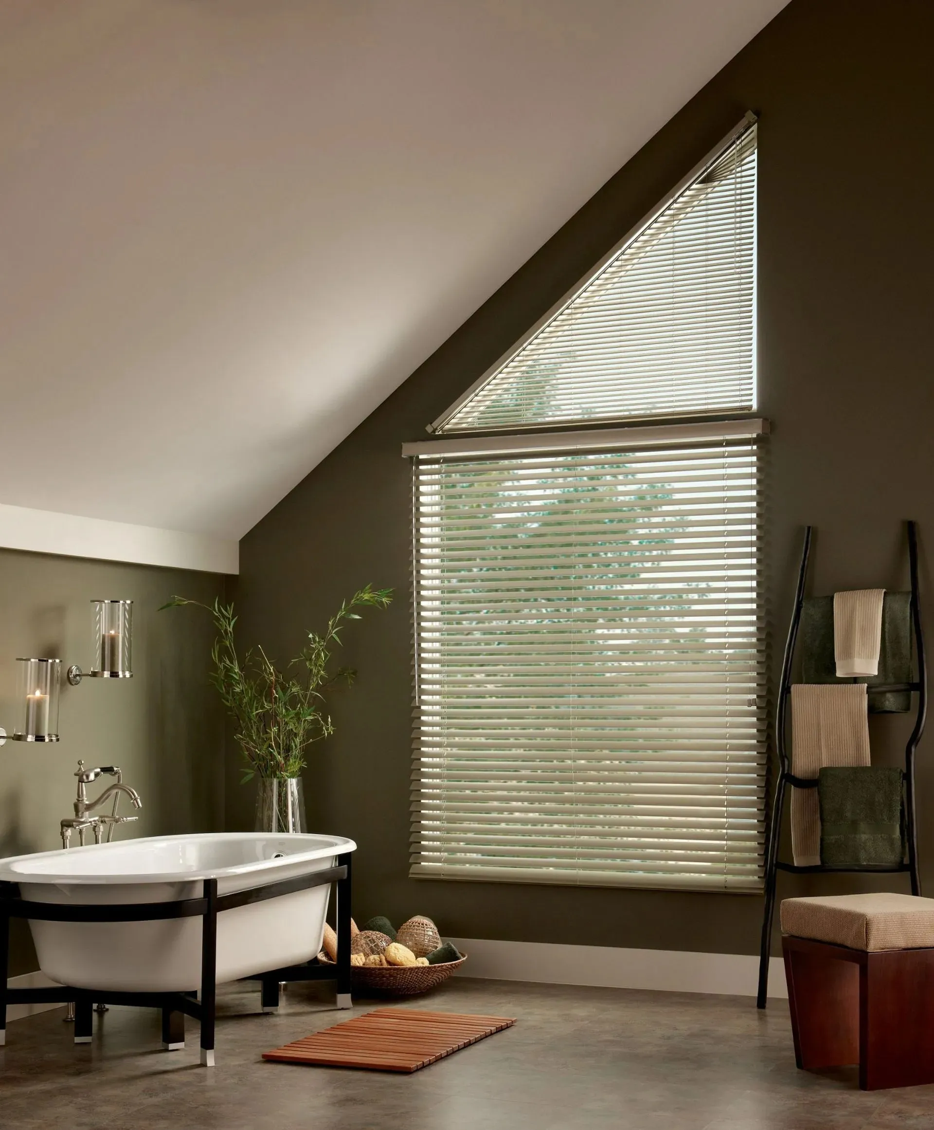 Horizontal blinds on an angled and rectangular window in a bathroom with a freestanding tub