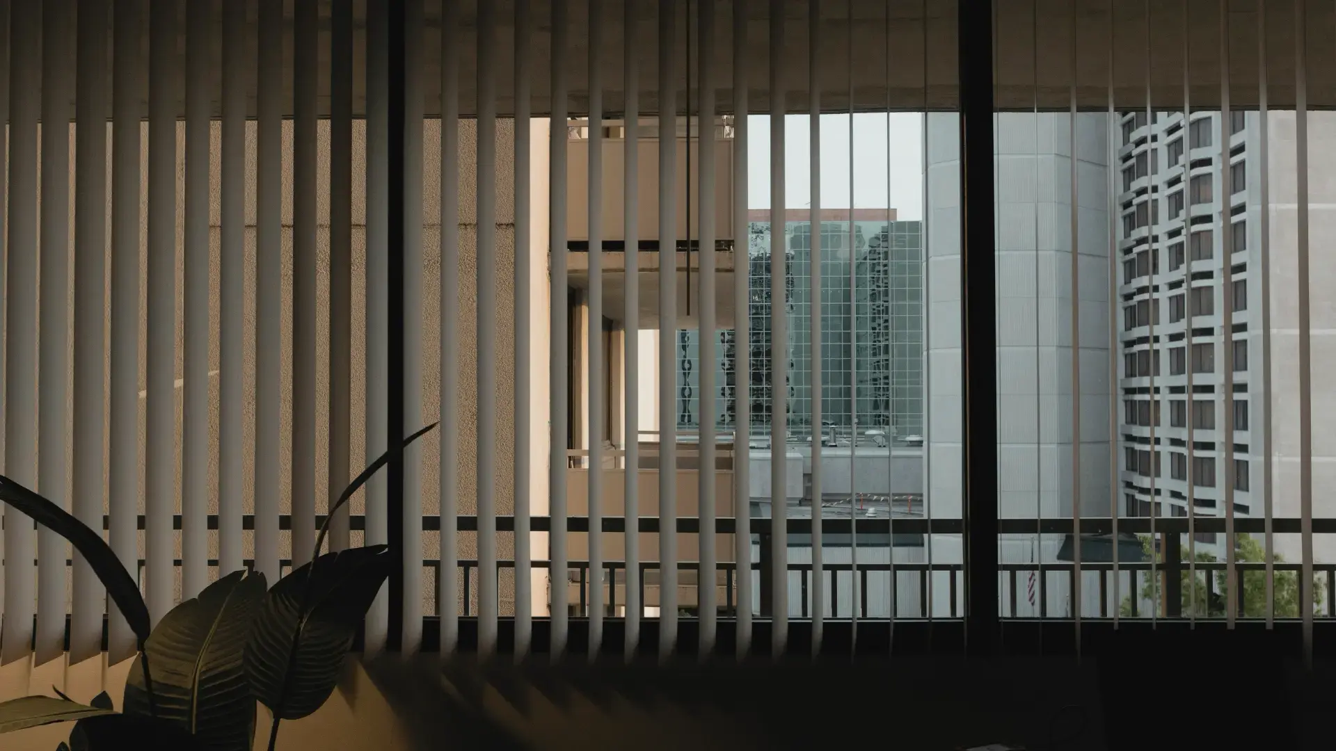 Vertical blinds on office windows overlooking downtown high-rise buildings