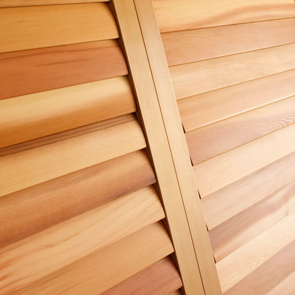 Close-up of natural cedar hardwood plantation shutter louvers and tilt rod