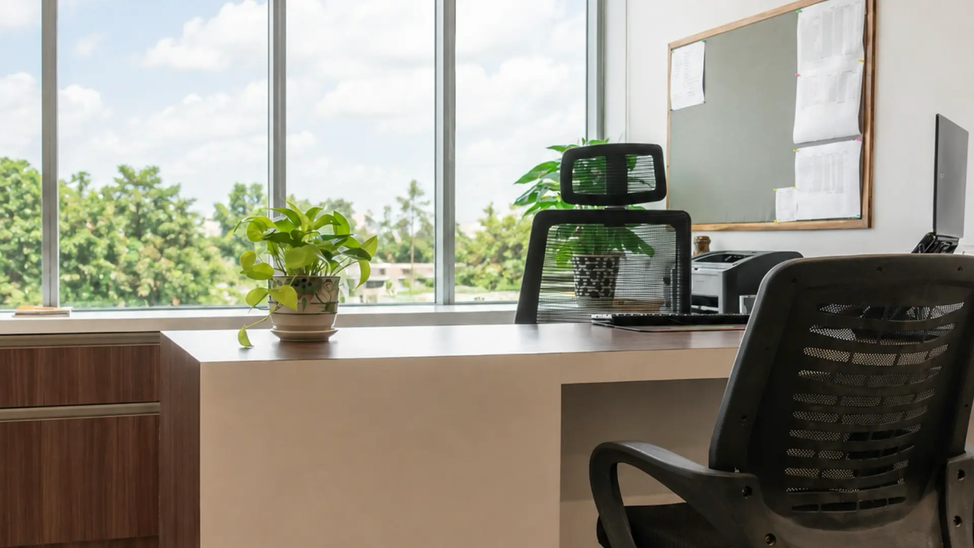 Office with bare windows behind a desk, before installing blinds