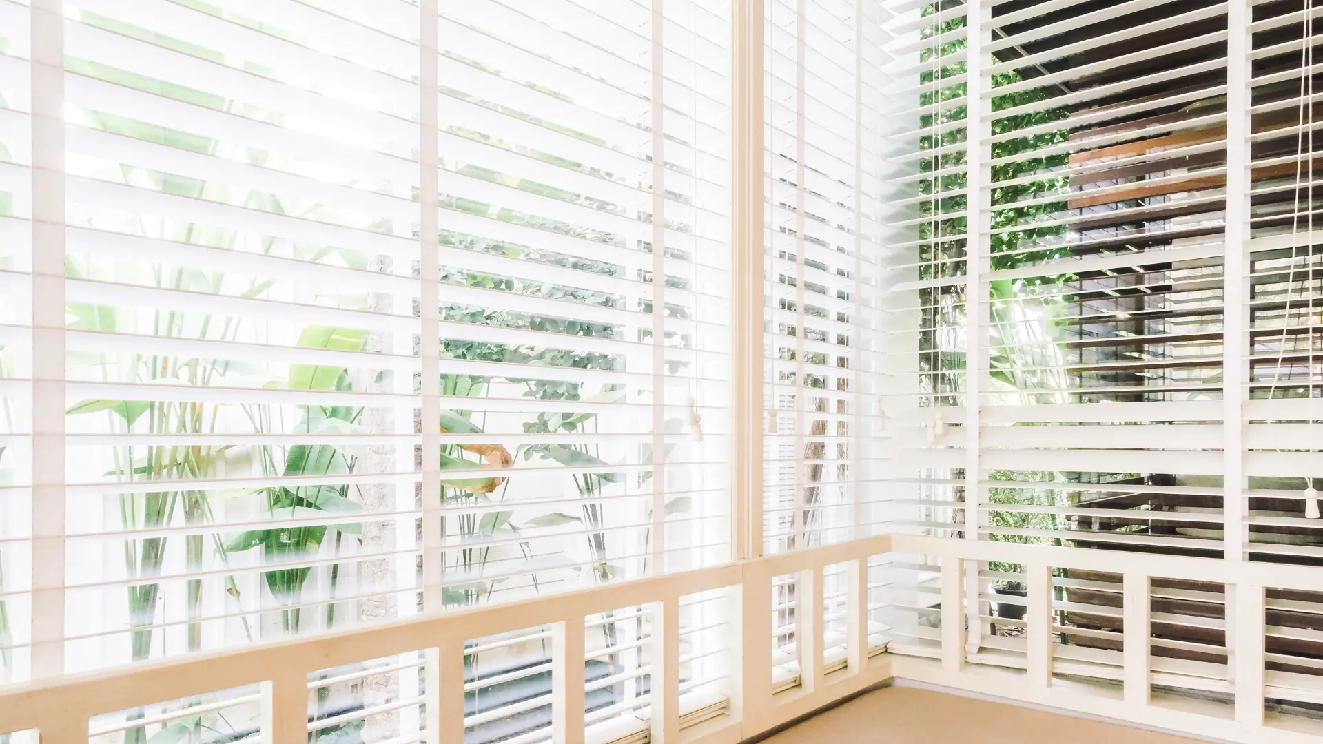 White louvered designer shutters on a bright corner window