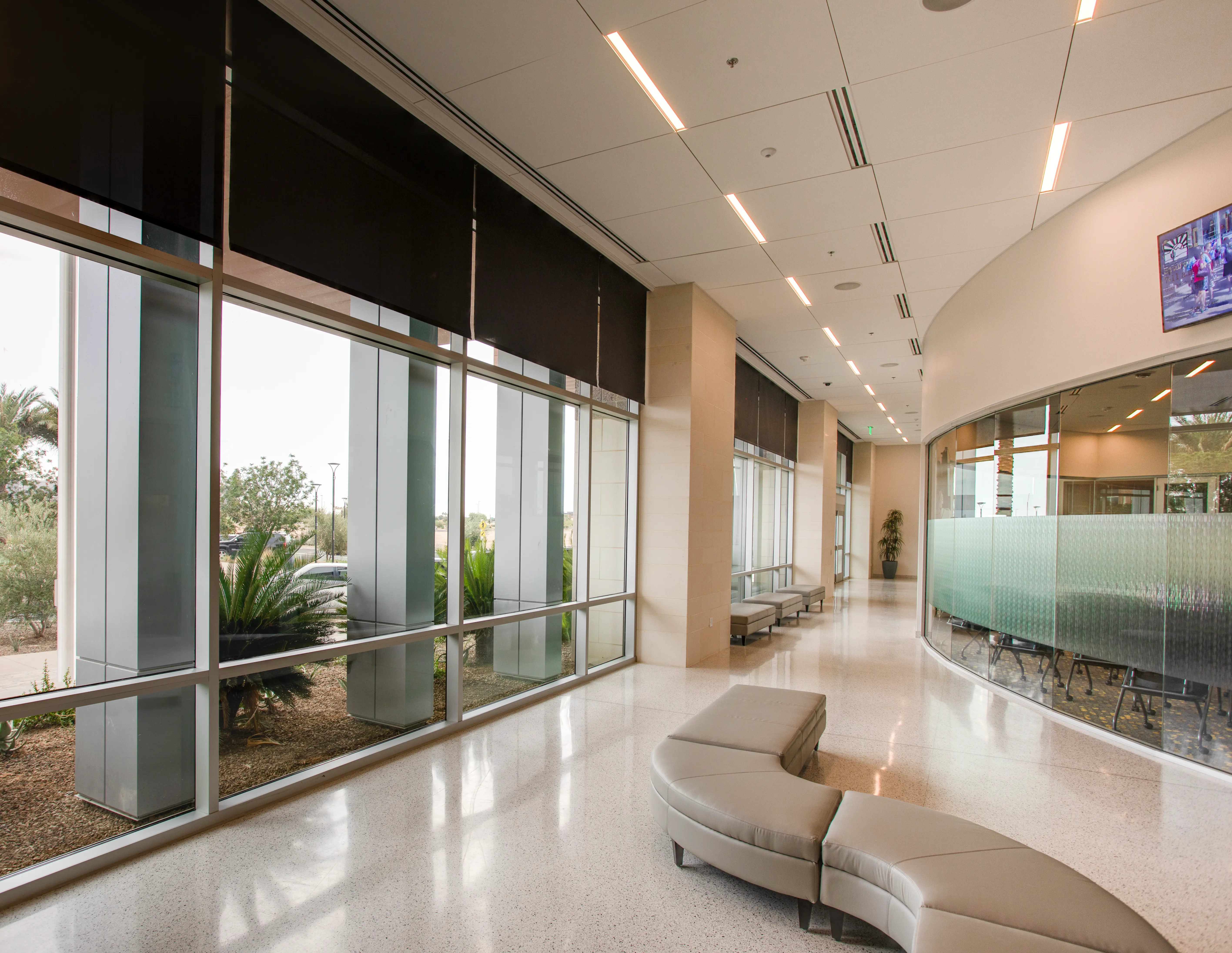 Public building lobby with roller shades raised above floor-to-ceiling windows