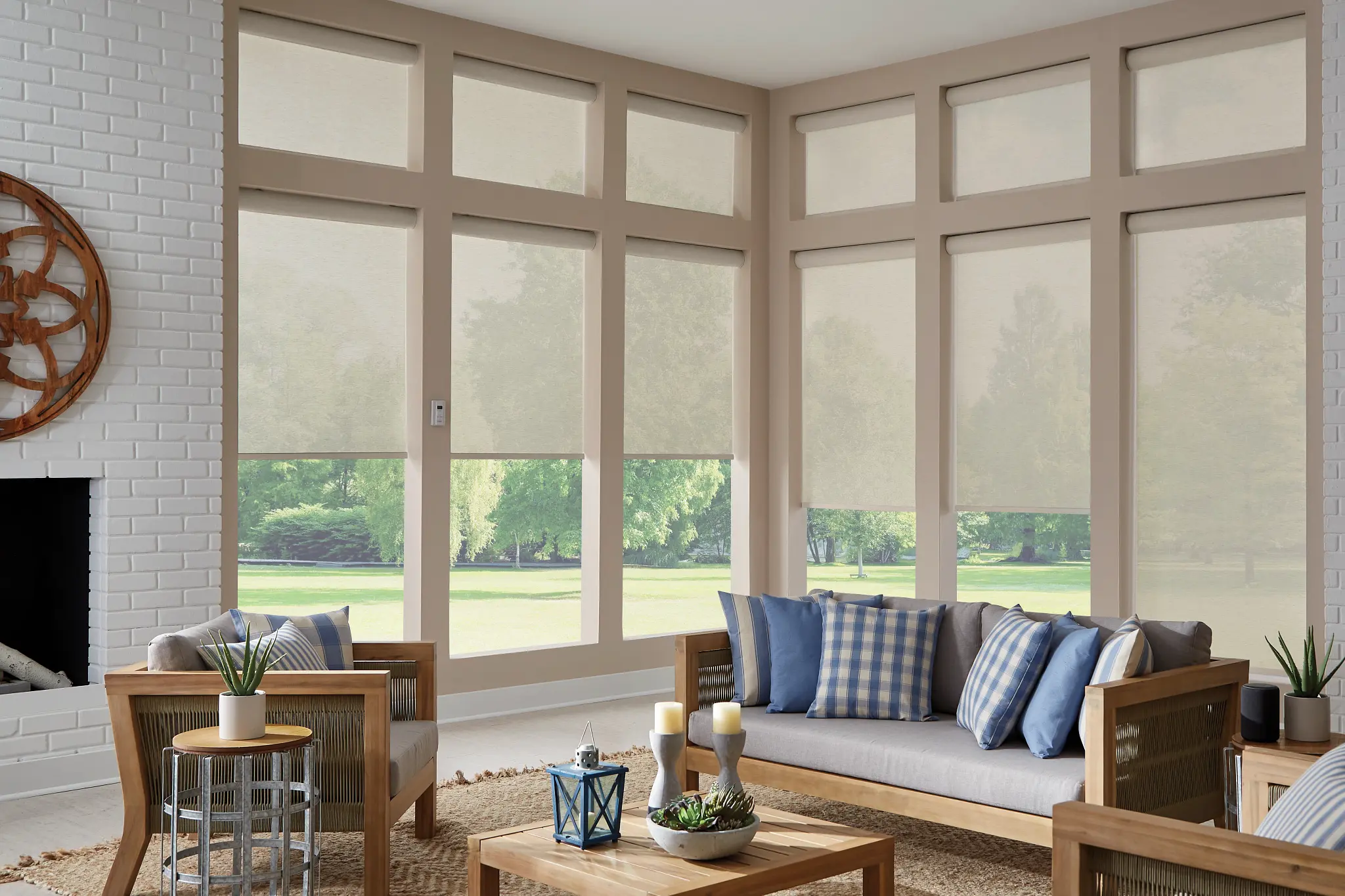 Light solar shades lowered on a sunroom's tall windows
