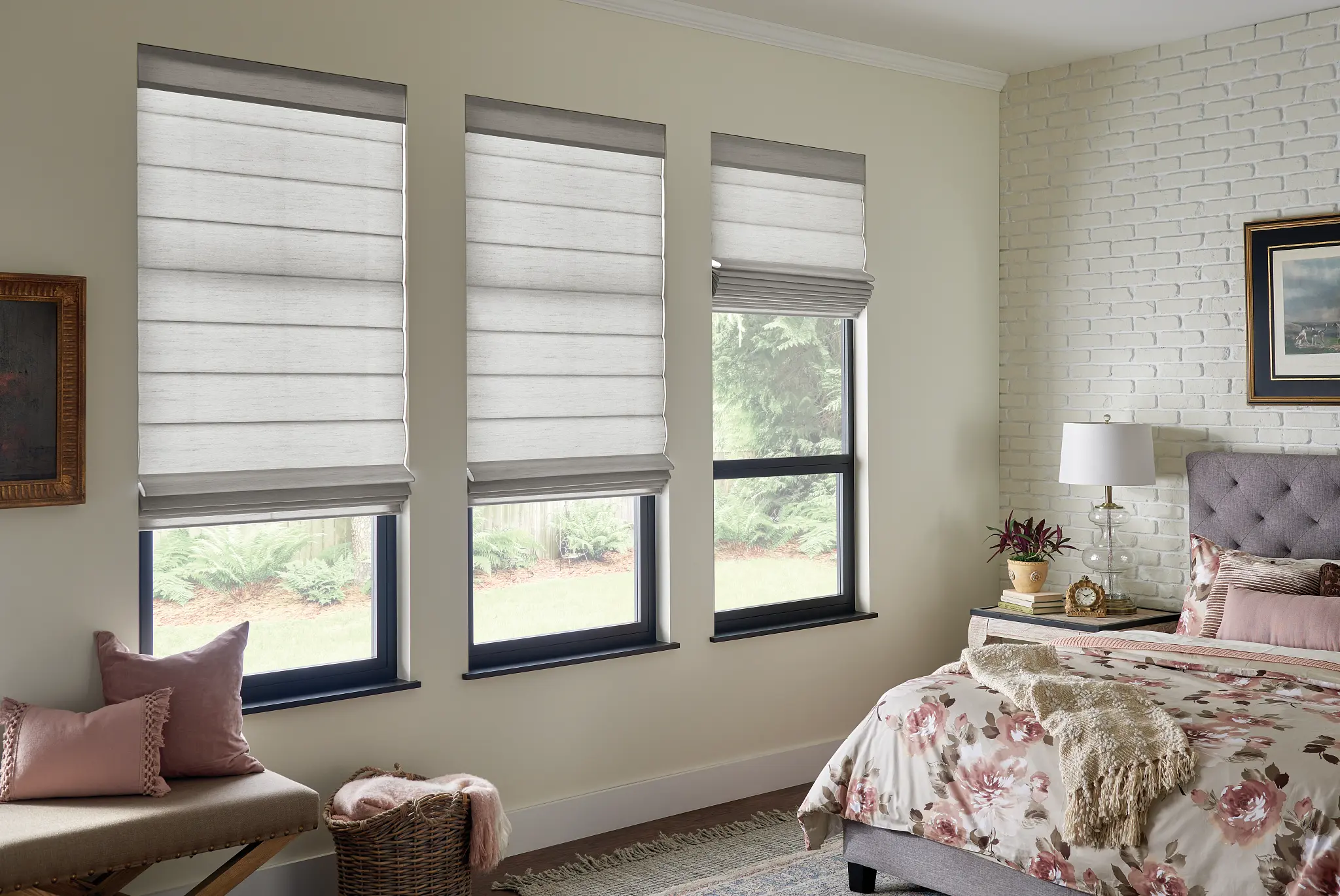 White Roman shades with gray trim on a row of bedroom windows