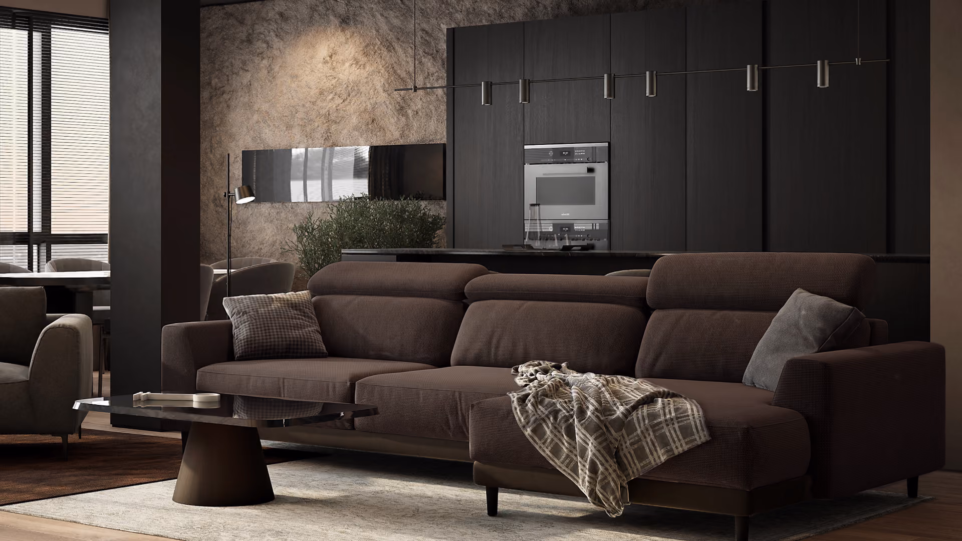 Modern living room with a dark brown sectional sofa adorned with cushions and a plaid throw, a low black coffee table on a light rug, and a backdrop of dark cabinetry and textured wall, illuminated softly.