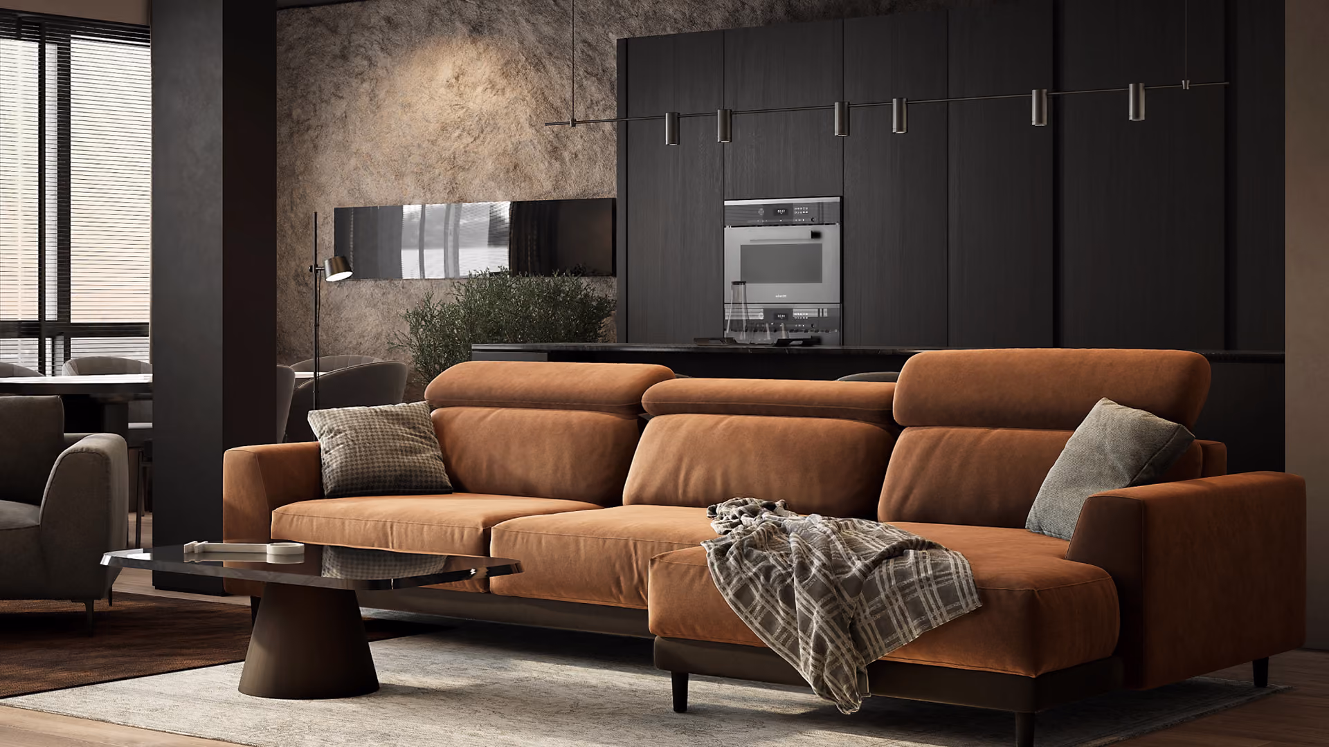Modern living room featuring a large brown suede sectional sofa with two pillows and a plaid throw, a dark wood coffee table on a light rug, and a backdrop of dark kitchen cabinets with built-in appliances and a textured accent wall.
