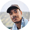 Man with mustache wearing a beige cap and light blue shirt looking at the camera.