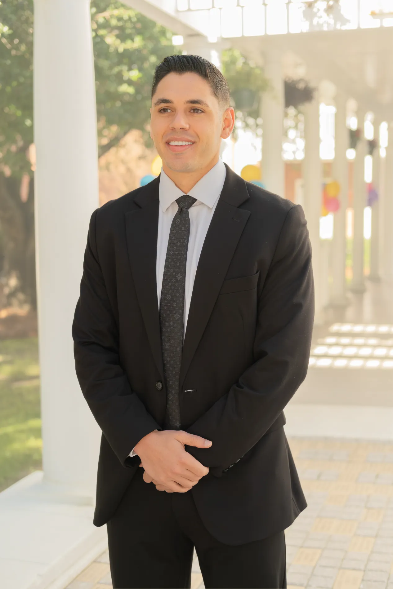 Attorney Edon Saiyag standing outdoors in a black suit