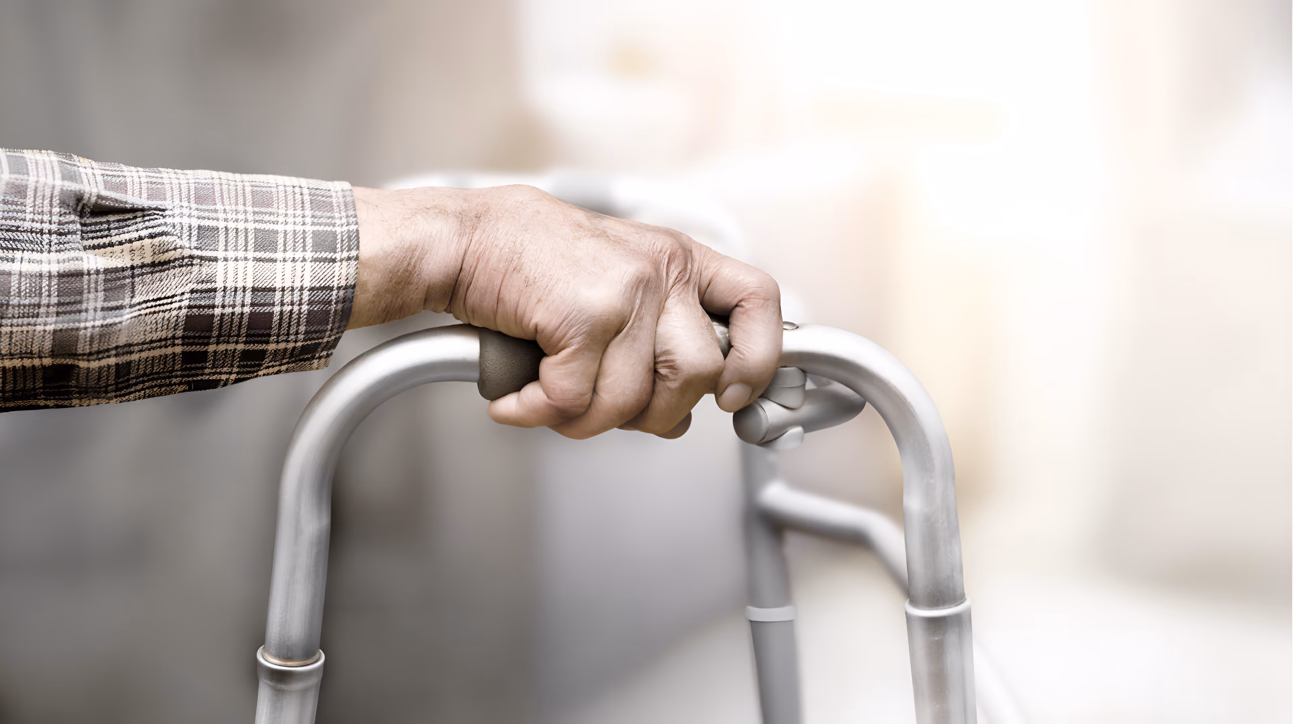 Older adult’s hand gripping a walker