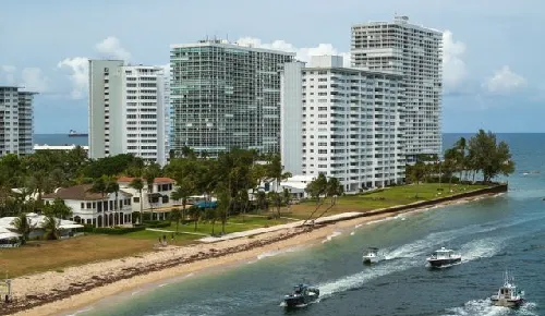 Boats traveling along a Fort Lauderdale waterway beside waterfront buildings