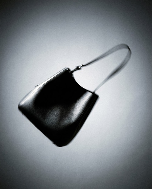 Woman wearing Beoplay H100 noise cancelling headphones with product details and purchase options overlay.